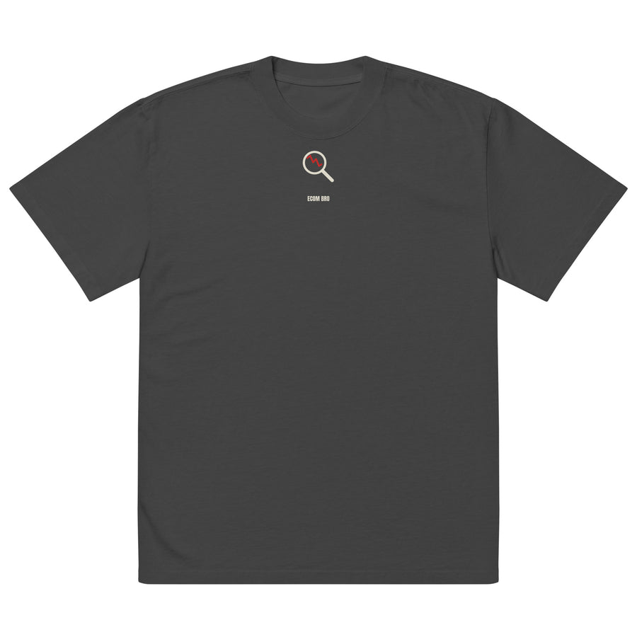 Supplier mockup, front of Faded Black cotton tee with a small cream-and-red DTG magnifying-glass design and ECOM BRO signature.