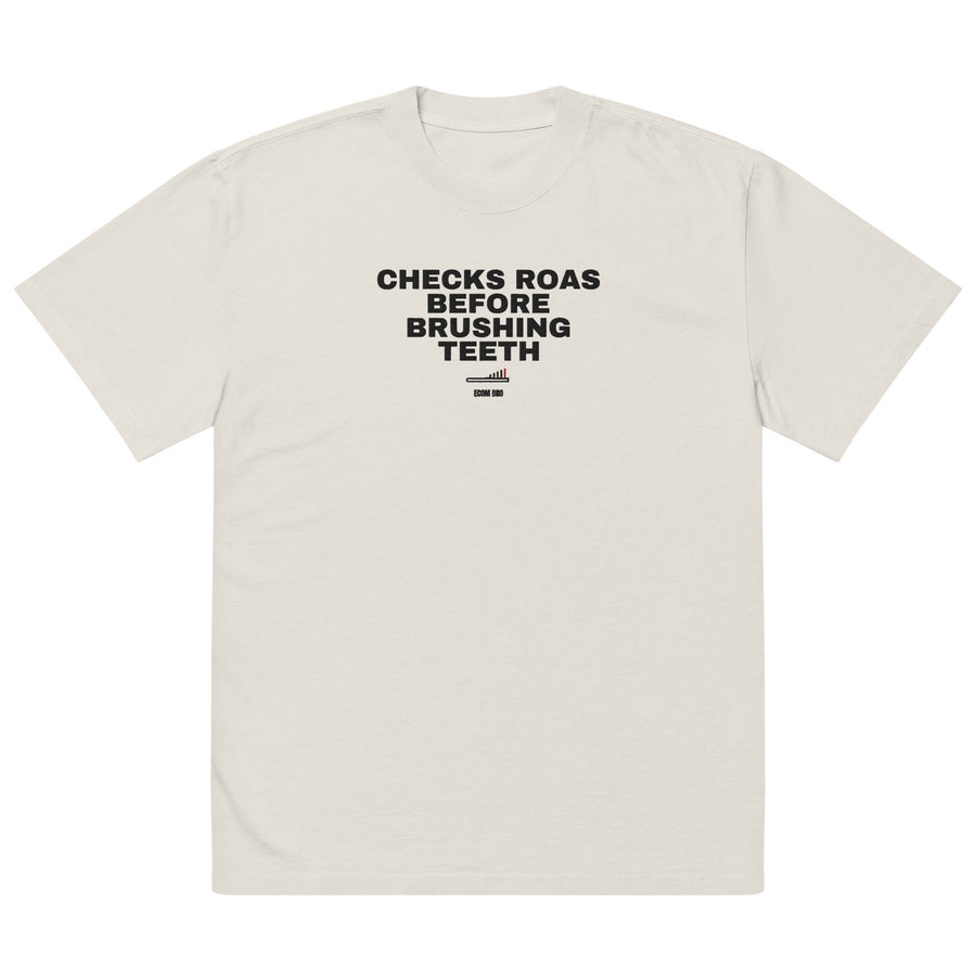 Front supplier mockup of the Faded Bone heavyweight tee with CHECKS ROAS BEFORE BRUSHING TEETH lettering above a toothbrush chart and ECOM BRO signature.