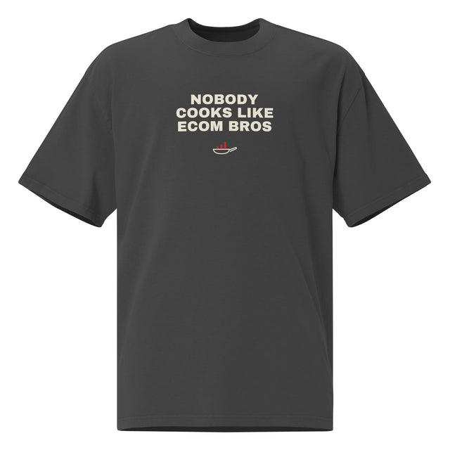 Supplier mockup, front of Faded Black cotton tee with cream DTG NOBODY COOKS LIKE ECOM BROS text and a cream frying-pan graphic with red rising bars.