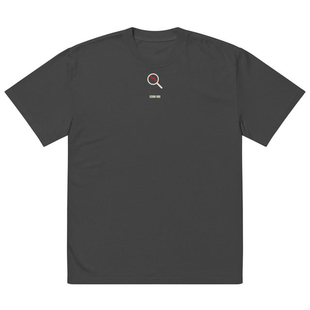 Supplier mockup, front of Faded Black cotton tee with a small cream-and-red DTG magnifying-glass design and ECOM BRO signature.