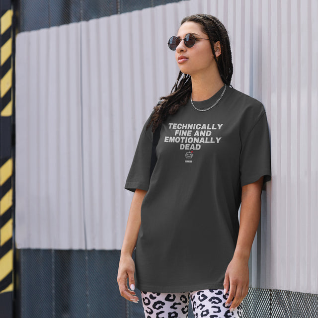 Supplier on-body mockup of the oversized fit: TECHNICALLY FINE AND EMOTIONALLY DEAD chest embroidery with a small robot below on Faded Black