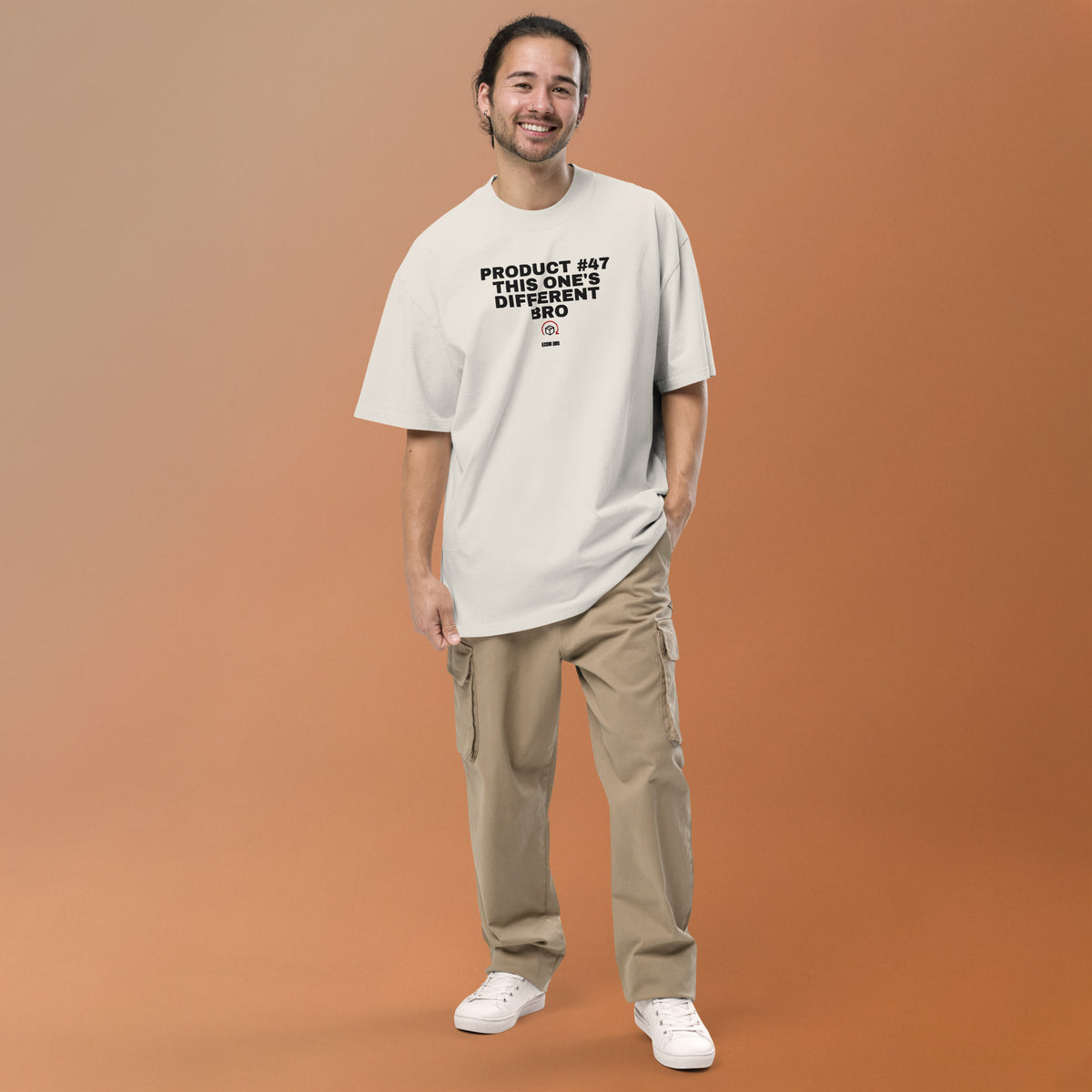 Supplier mockup: model in beige trousers wearing the Faded Bone Product #47 tee, showing the front embroidered headline, parcel-and-arrow icon and ECOM BRO signature.