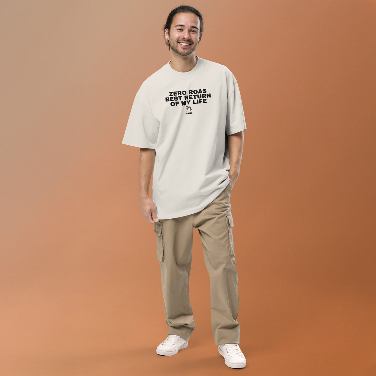 Supplier mockup: model in beige trousers wearing the Faded Bone Zero ROAS, Best Return of My Life tee, with embroidered front headline, adult-and-child heart icon and ECOM BRO signature.